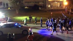 A Rock Hill, SC, police officer helps clear the way for firefighters to reach a fire started outside police headquarters Wednesday. A Rock Hill, SC, police officer helps clear the way for firefighters to reach a fire started outside police headquarters Wednesday.