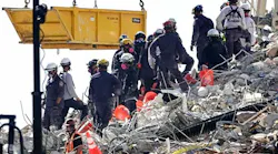 A bucket brigade works to remove debris from the Champlain Towers South Condo collapse Monday in Surfside, FL.