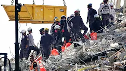 A bucket brigade works to remove debris from the Champlain Towers South Condo collapse Monday in Surfside, FL.