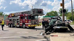 Two Toledo, OH, firefighters suffered minor injuries when the aerial they were in was struck by an SUV on Monday, killing a man in the civilian vehicle and critically injuring another.