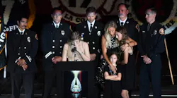 Joslyn Carlon holds back tears as she speaks next to her mother and sisters about her father, fallen L.A. County firefighter Tory Carlon, during a memorial at the Forum in Inglewood on Thursday.