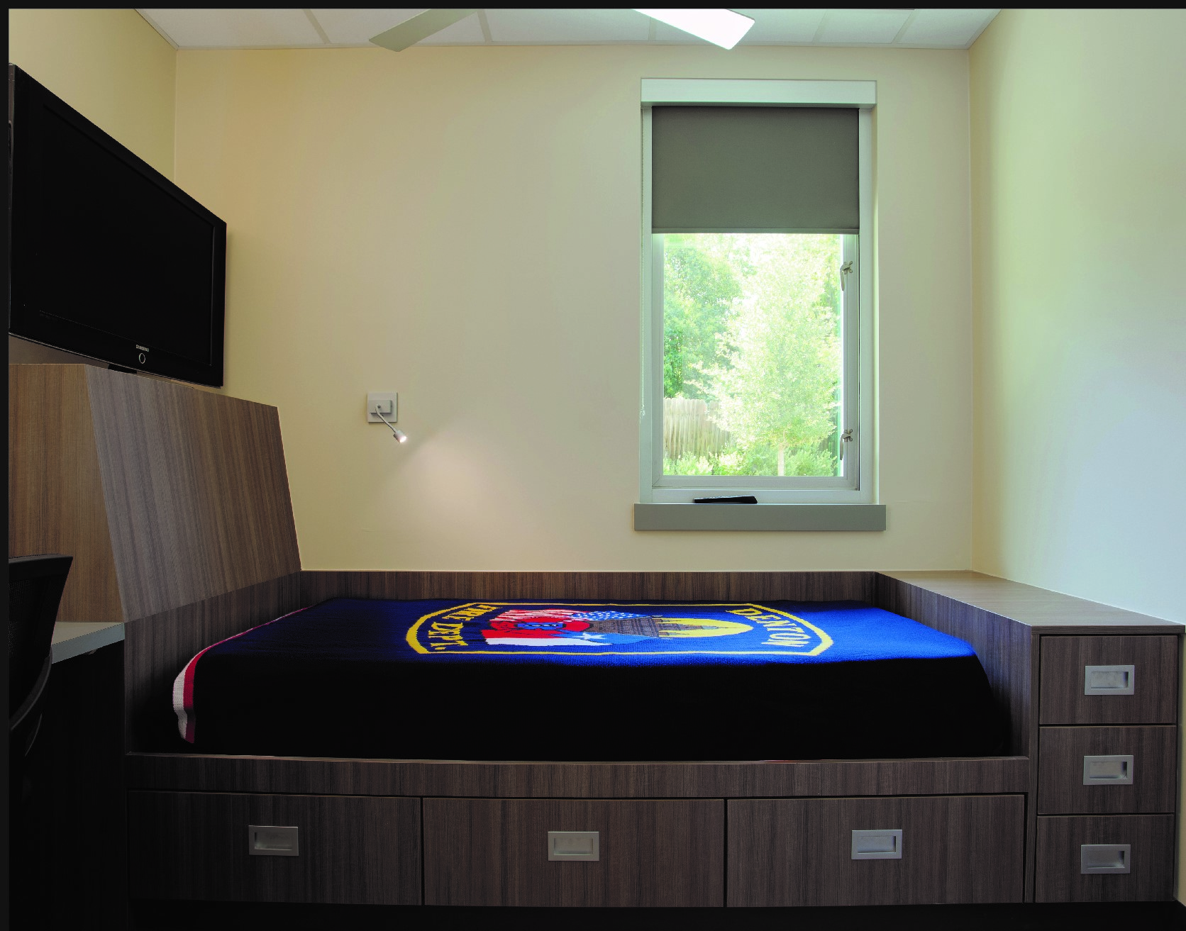 This individual sleep room includes a built-in (read: millwork) bed, a black-out shade, a task light and a built-in desk. Three vertically stacked drawers are at the foot of the bed. Storage under the standard-height mattress platform is adequate if bulky bed linens can be stored elsewhere.