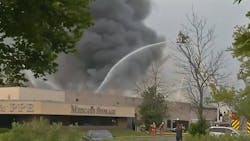 Firefighters battle a large fire that broke out at an Amherst, NY, PPE factory Tuesday.