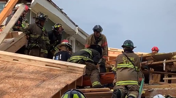 D.C. Fire & EMS firefighters rescued a worker who was trapped for more than an hour beneath a collapsed building Thursday.