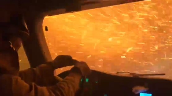 A University of California-Davis braves flames and a shower of sparks as he drives through the Tamarack Fire to protect a housing development Wednesday.