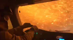 A University of California-Davis braves flames and a shower of sparks as he drives through the Tamarack Fire to protect a housing development Wednesday.