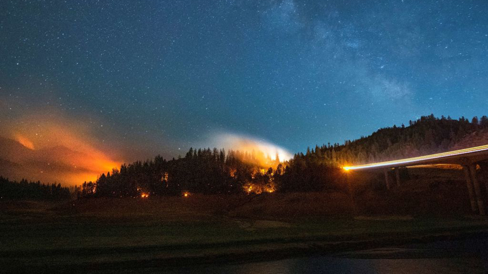 In this long exposure photograph, flames surround a drought-stricken Shasta Lake during the Salt fire in Lakehead, CA, on July 2, 2021.