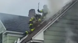 Firefighters ventilate the roof of a house during a two-alarm fire in West Haven, CT, on Thursday.