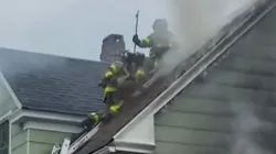 Firefighters ventilate the roof of a house during a two-alarm fire in West Haven, CT, on Thursday. Firefighters ventilate the roof of a house during a two-alarm fire in West Haven, CT, on Thursday.