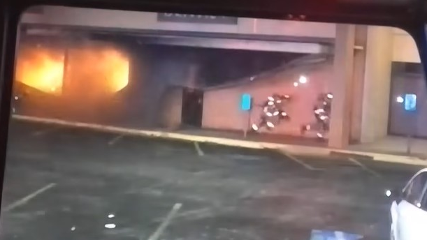 Two Longview, TX, firefighters try to escape the partial collapse of an awning during an intentionally set three-alarm fire Aug. 7.