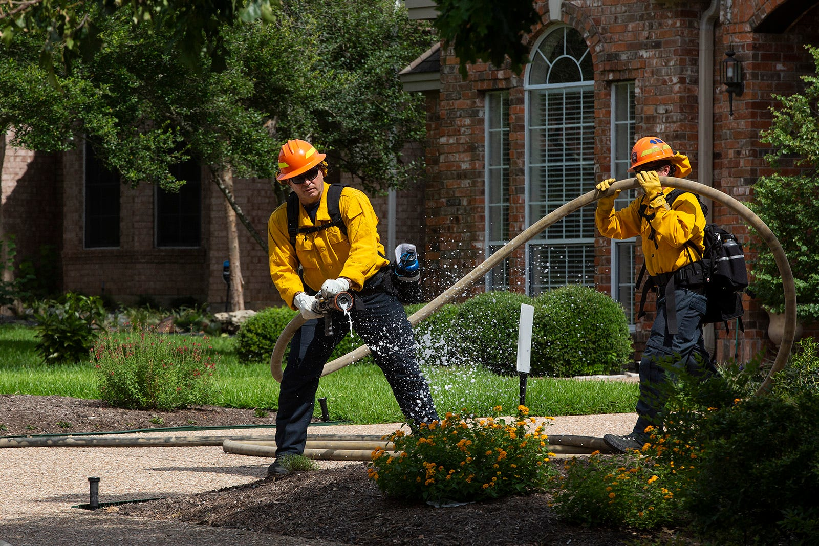 An Austin firefighter simulates a fire during a wildfire exercise in West Austin on Tuesday.