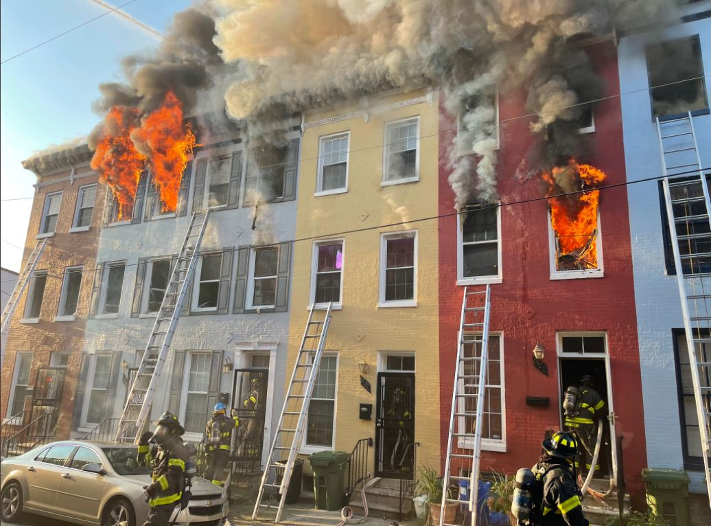 Baltimore firefighters work to contain a four-alarm fire on Fairmount Avenue Friday morning.
