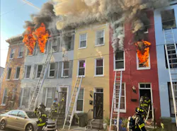 Baltimore firefighters work to contain a four-alarm fire on Fairmount Avenue Friday morning.