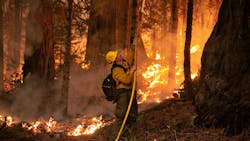 A firefighter works to contain the Caldor Fire on Saturday, Aug. 28, 2021, in Strawberry, CA.