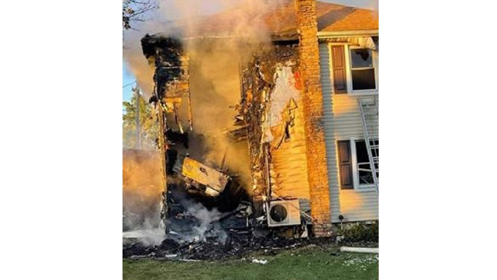 The rear of a pickup can be seen amid smoke after a driver was killed crashing into a home which then caught fire in Lancaster County, PA, on Wednesday, Sept. 29, 2021.