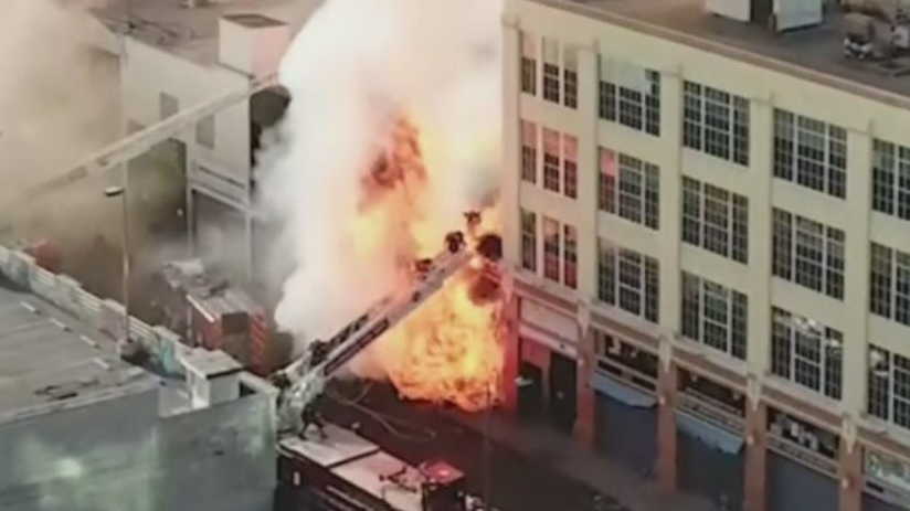 LAFD firefighters can be seen bailing down an aerial ladder as flames overtake them during an explosive fire at a vaping supply shop in May 2020.