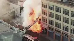 LAFD firefighters can be seen bailing down an aerial ladder as flames overtake them during an explosive fire at a vaping supply shop in May 2020.