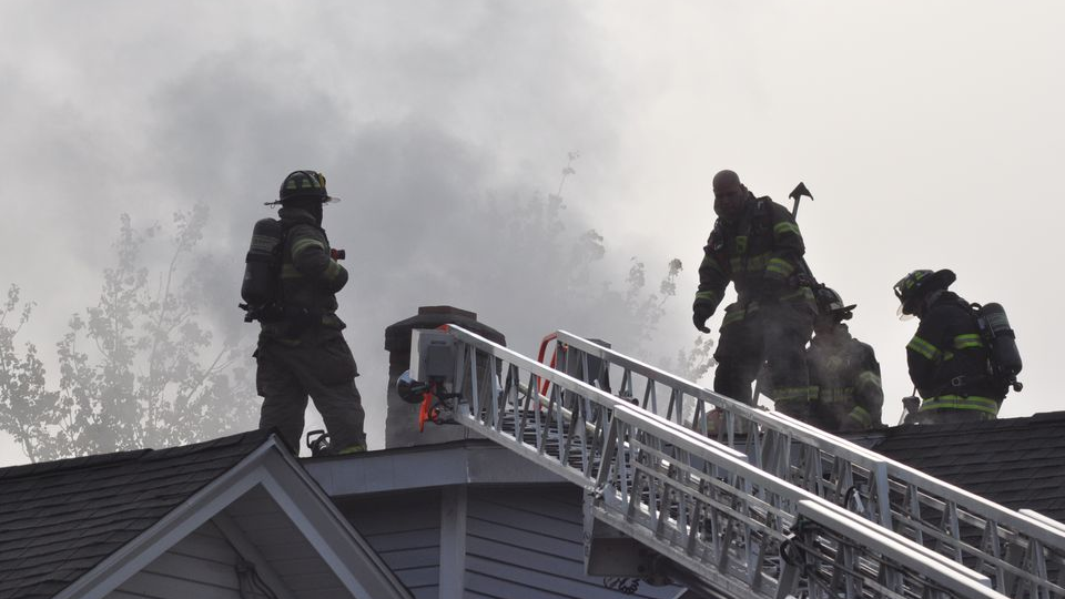 Springfield, MA, firefighters at work on on the roof of a burning home on Friday, Oct. 15, 2021.