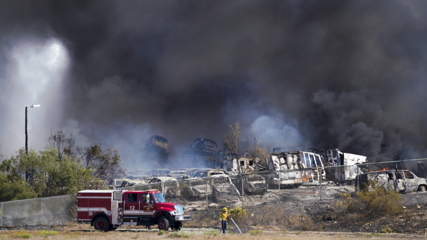Firefighters work to extinguish a fire at a junk yard in Otay Mesa on Saturday.