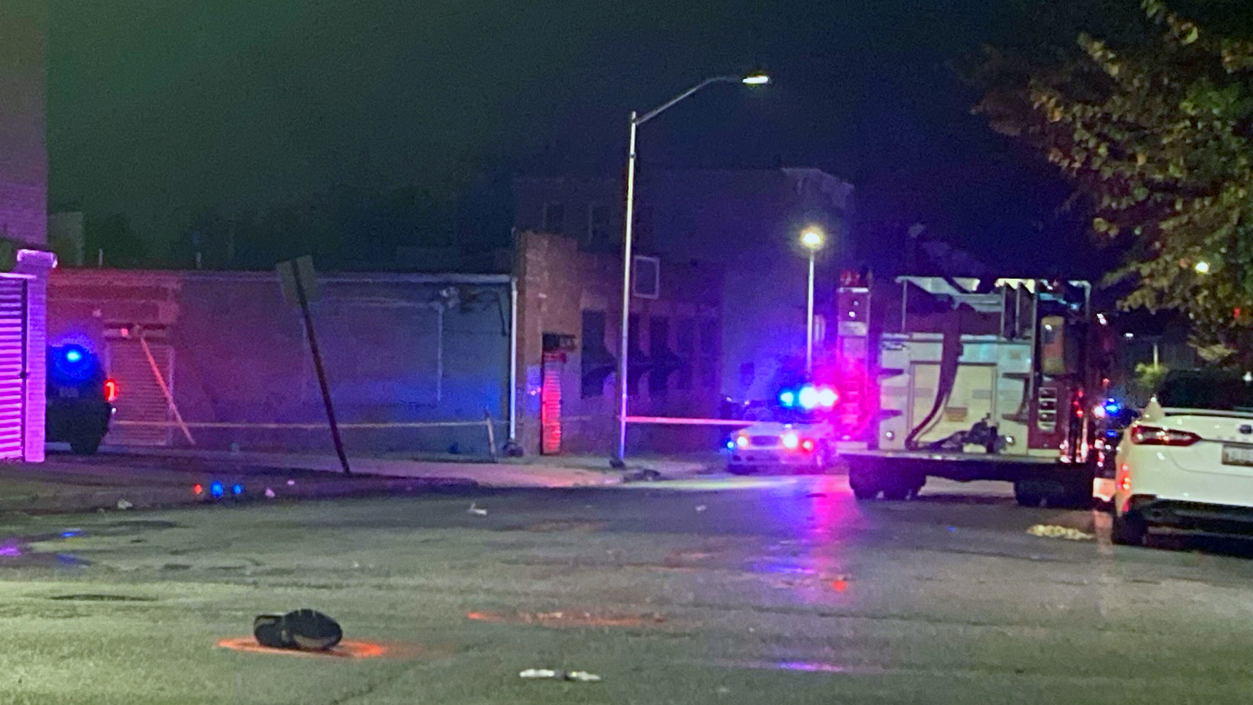 The shoe of a dirtbike rider sits in the foreground after he was struck and killed by a responding Baltimore fire apparatus on Thursday, Oct. 21, 2021.
