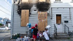 Neighbors pay their respects outside a boarded-up home where a man and his 14-year-old nephew perished in a fire in Allentown, PA, in July 2020. Neighbors pay their respects outside a boarded-up home where a man and his 14-year-old nephew perished in a fire in Allentown, PA, in July 2020.