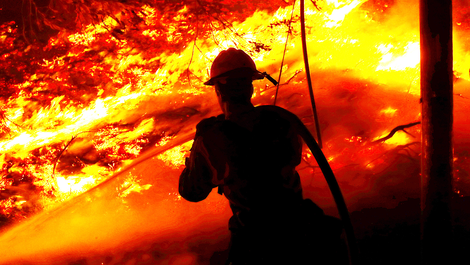 A firefighter battles the Alisal Fire along the 101 Freeway near Goleta, CA, on Tuesday, Oct. 12, 2021.