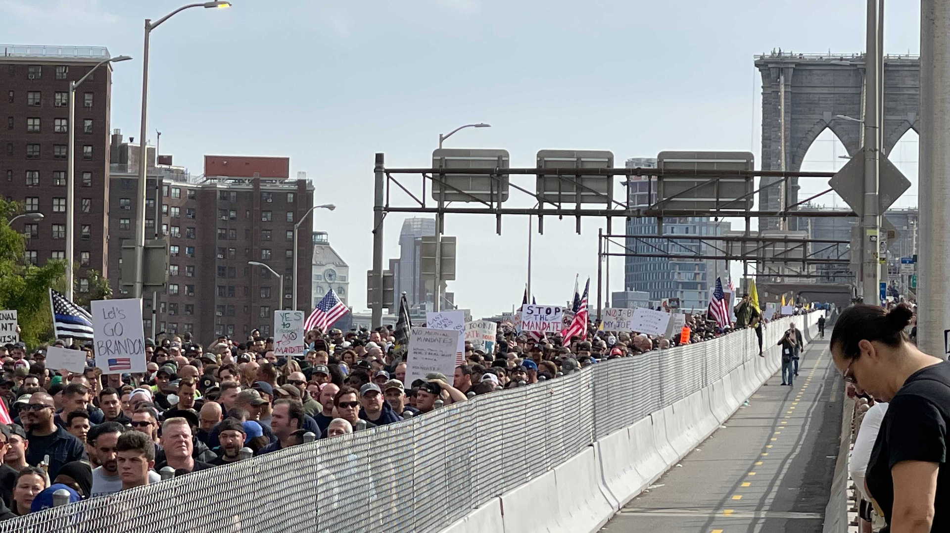 Hundreds of New York City municipal employees and their supporters march over the Brooklyn Bridge roadway on Monday, Oct. 25, 2021, in protest of the city's looming vaccine mandate.
