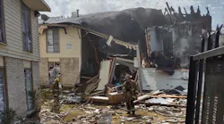 Firefighters survey the damage after a massive explosion tore through a Dallas apartment building on Sept. 29, 2021.