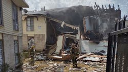 Firefighters survey the damage after a massive explosion tore through a Dallas apartment building on Sept. 29, 2021.