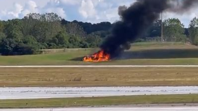 A small plane burns after crashing in a field next to a runway at DeKalb-Peachtree airport in Chamblee, GA, on Friday Oct. 8, 2021.