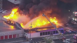 A Volkswagen dealership burns in a massive multi-alarm fire in Linden, NJ, on Friday, Oct. 29, 2021.