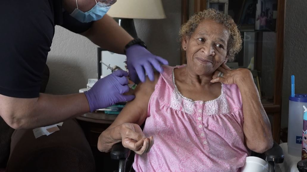 An Oklahoma City firefighter administers a COVID-19 vaccination to Mary Johnson, a homebound resident.