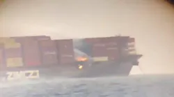 Flames can be seen among shipping containers on a cargo vessel sitting about 5 miles off the coast of British Columbia on Saturday, Oct. 24, 2021.