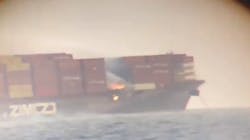 Flames can be seen among shipping containers on a cargo vessel sitting about 5 miles off the coast of British Columbia on Saturday, Oct. 24, 2021.