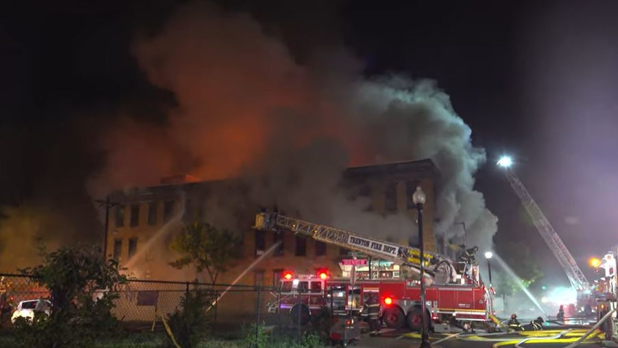 Smoke pours from a burning three-story building in Trenton, NJ, on Thursday, Oct. 14, 2021.