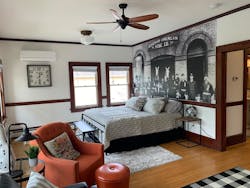The bedroom of the 800-square-foot second floor features a photo of the firefighters and horses assigned to the station and other memorabilia. The bedroom of the 800-square-foot second floor features a photo of the firefighters and horses assigned to the station and other memorabilia.