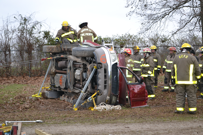 Having completed a stabilization scenario that found the side of the vehicle “obstructed,” members of a rescue team carry out other technician-level tasks that are included in “Technician-Level Hands-On Skills Checklist for a Roof-Resting Passenger Vehicle.”