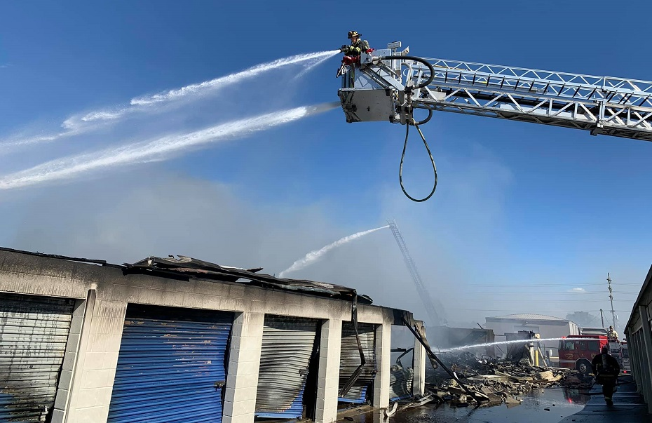 Firefighters work to extinguish a fire that tore through two buildings containing storage units in Owensboro, KY, on Thursday, Oct. 21, 2021.