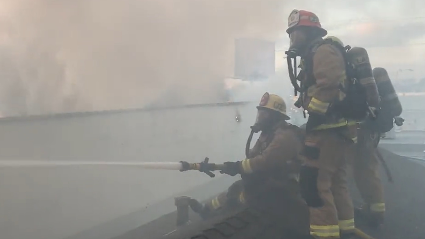 L.A. County firefighters apply water to a three-alarm fire in a storage facility in the city of Bellfower.