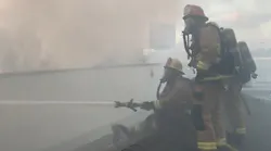L.A. County firefighters apply water to a three-alarm fire in a storage facility in the city of Bellfower.