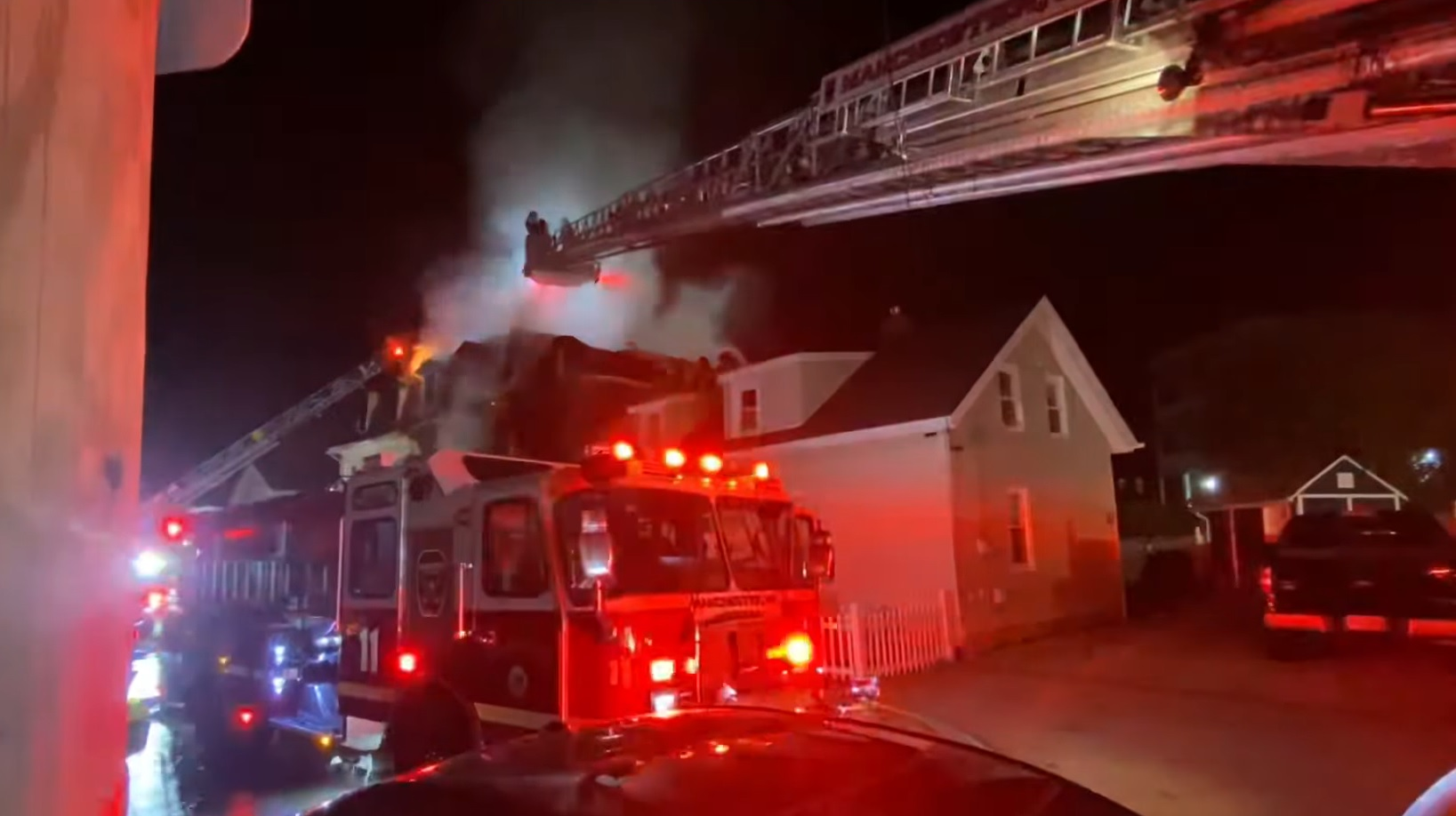 Aerials operate during a house fire that badly burned Manchester, NH, Fire Capt. Steve DesRuisseaux on Saturday, Nov. 6, 2021.
