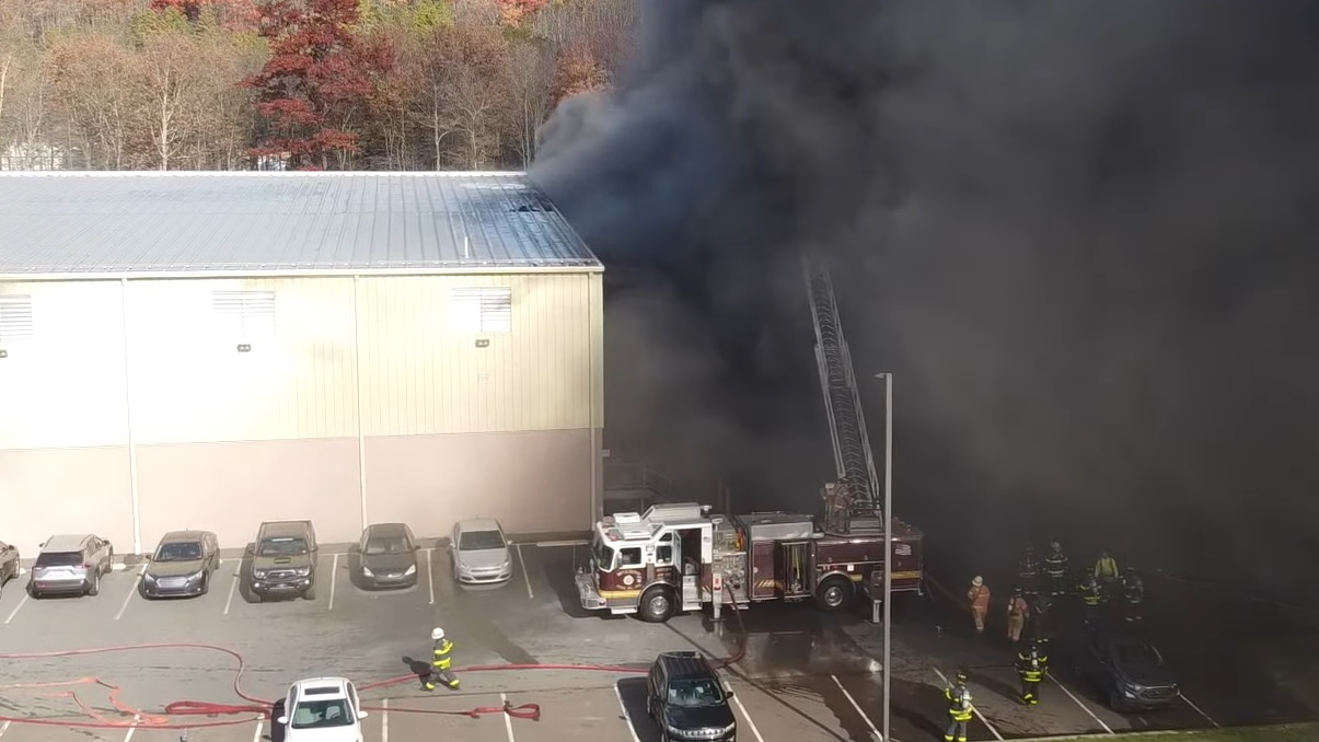 Firefighters use a ladder truck to control the fire during operations at a furniture manufacturer in Rush Township, PA.