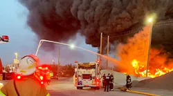 Firefighters use elevated waterways to control a multiple-alarm fire at a recycling center.