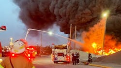 Firefighters use elevated waterways to control a multiple-alarm fire at a recycling center. Firefighters use elevated waterways to control a multiple-alarm fire at a recycling center.