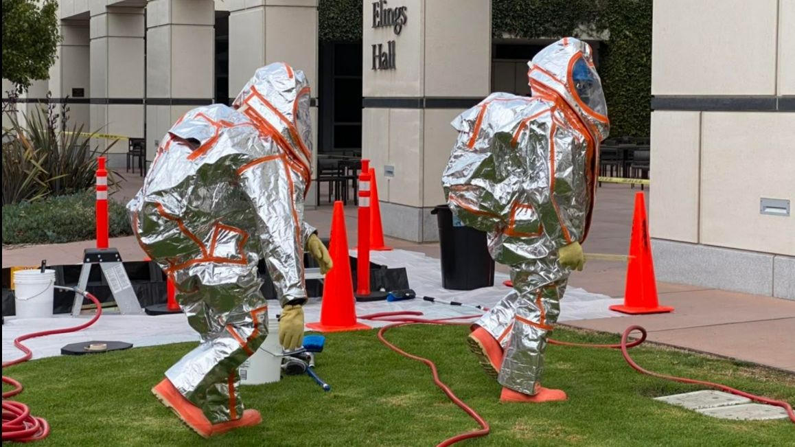 Hazardous Materials team members prepare to make entry to monitor for leaks at a building on the campus of UC Santa Barbara in Isla Vista, CA.