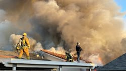 Police stand by with a rifle as Ventura County firefighters operate at a dwelling fire that was intentionally set. Police stand by with a rifle as Ventura County firefighters operate at a dwelling fire that was intentionally set.