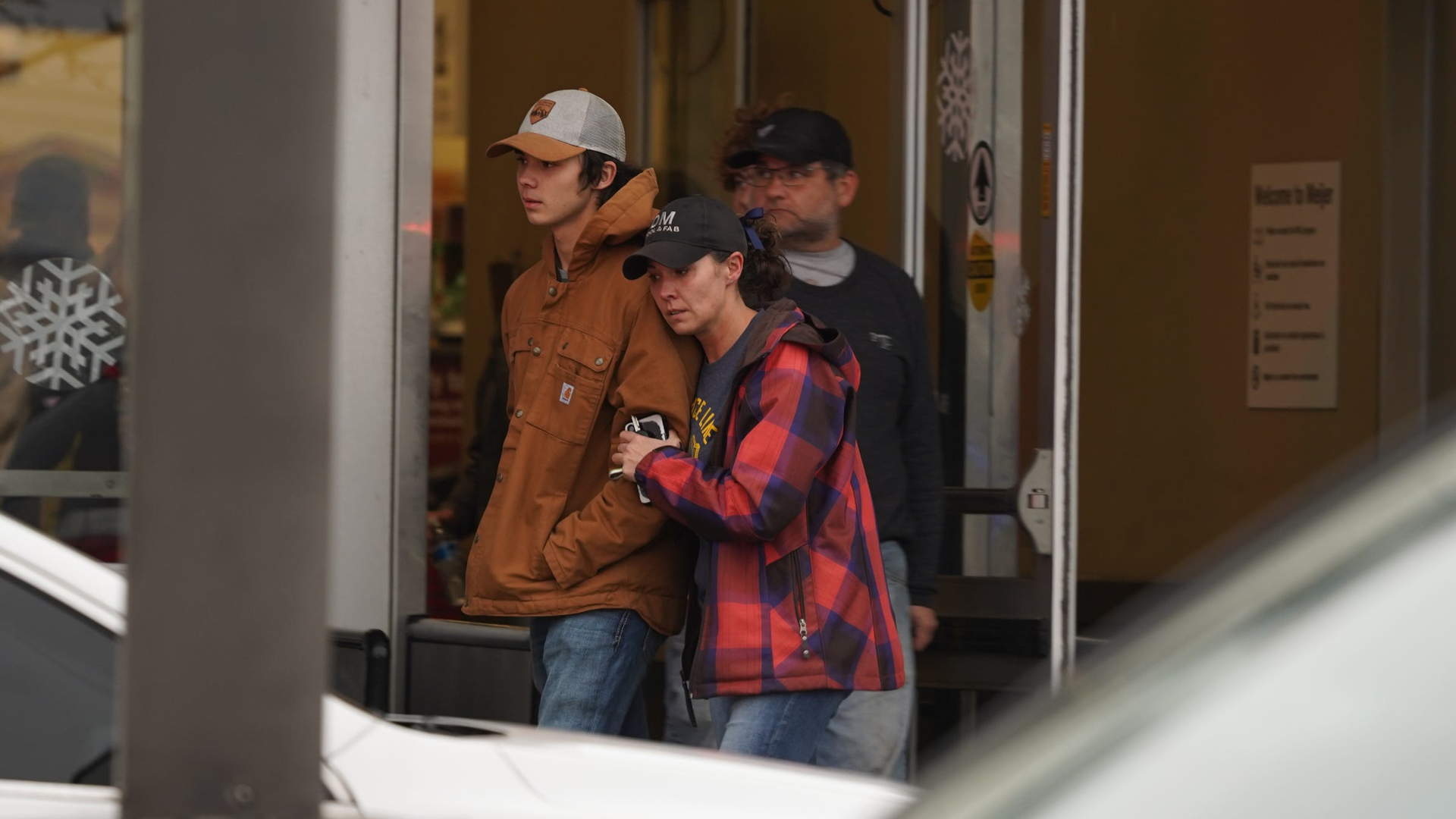 A parent hugs a child as at the store where students from the Oxford High School were taken after a student opened fire at the school Tuesday.