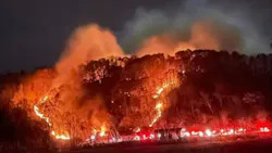 Fire advances up a hillside after being sparked by a structure fire in Harrison County, WV.