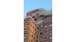Smoke pours from the upper floors of a Bronx apartment building during a fire that killed a six-year-old boy on Friday, Nov. 5, 2021.