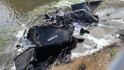 The shell of a burned-out semi-truck sits in a canal in Boynton Beach, FL, after crashing and catching fire on Wednesday, Nov. 17, 2021.